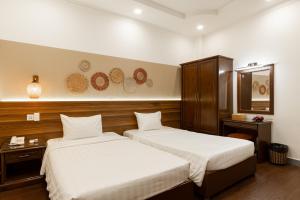 胡志明市Lantern Hotel的酒店客房,设有两张床和镜子