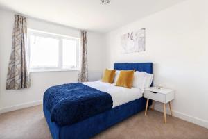 SwanscombeLuxury Modern 2 Bed Apartment in Ebbsfleet - 20mins from London的一间卧室设有蓝色的床和窗户。