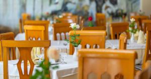 甘达坞伊港康大维港埃尔莫拉蒂酒店的一间用餐室,配有桌椅和花朵