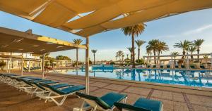 甘达坞伊港康大维港埃尔莫拉蒂酒店的一个带躺椅和棕榈树的游泳池