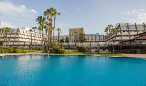 伊斯兰蒂拉伊斯兰蒂拉吕尼翁酒店的大楼前的大型蓝色游泳池