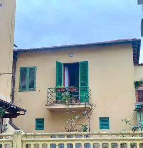 蒙特卡蒂尼泰尔梅Appartamento Meri, Montecatini Terme的一座带绿色百叶窗和阳台的建筑