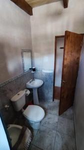 蒂尔卡拉Retama的一间带卫生间、水槽和镜子的浴室