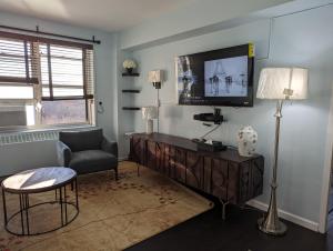 纽约Fully renovated Manhattan gem的一间带电视和椅子的客厅