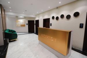 杜尚别BALAND HOTEL DUSHANBE的大堂设有绿色沙发和墙上的盘子