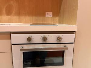 圣保罗MARCOLINI - Flat Luxo Bela Cintra的厨房配有白色烤箱、吧台