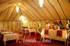 梅尔祖卡Nomada Domes的帐篷配有桌椅和灯光