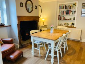 AdlingtonAdlington Cottage, Lancashire的餐桌、椅子和壁炉