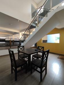 San Juan del ParanáHotel Villa的一间带桌椅和楼梯的用餐室