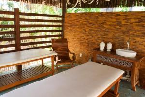 塔曼达雷Hotel Coral Beach的客房设有水槽、桌子和椅子。