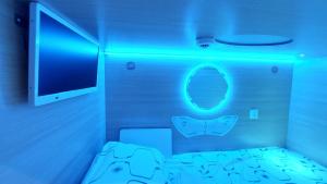 里加欢乐酒店的一间设有一张蓝色灯光床的客房