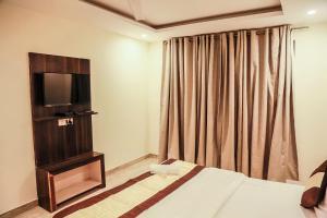 新德里Hotel Global Radiance Stay Near Delhi Airport的酒店客房,配有床和电视