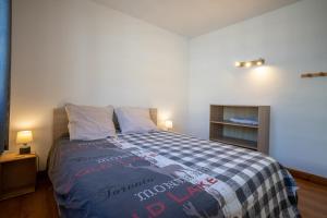 圣拉里苏朗Grand Chalet St-Lary centre 13 à 15 pers的一间卧室配有一张带蓝白色毯子的床