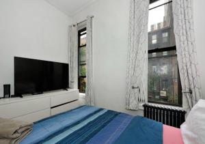 纽约Designer 2BD 1BA In Upper East side的一间白色卧室,配有电视和一张床