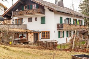 巴特科尔格鲁布Haus Alpenquelle Seeblick的一座带绿色百叶窗和阳台的古老房子