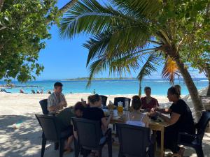 图鲁斯杜Ocean Cottage Maldives的一群人坐在海滩上的桌子上