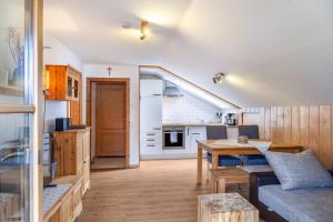 巴特科尔格鲁布Haus Alpenquelle Seeblick的厨房以及带沙发和桌子的客厅。
