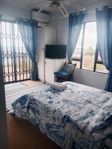 阿曼济姆托蒂Bayview Guest House的一间卧室配有一张床、一把椅子和窗户。
