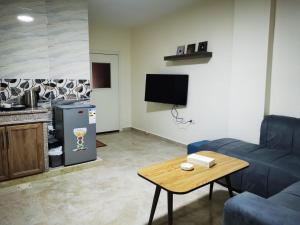 瓦迪穆萨Hospitality apartments的客厅配有蓝色的沙发和桌子