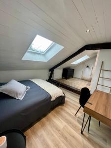 勒伯吉特杜拉克La Casa du Lac的一间卧室配有一张床和一张书桌,天窗