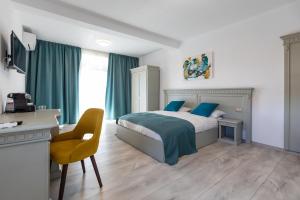 Sub CoastăSky Rooms by Volo Guest House的一间卧室配有一张带蓝色枕头的床和一张书桌