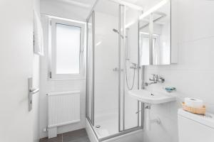 洛桑Sallaz Residence by Homenhancement的带淋浴和盥洗盆的白色浴室