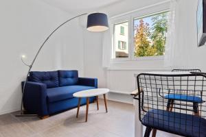 洛桑Sallaz Residence by Homenhancement的客厅配有蓝色的沙发和桌子
