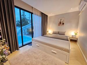华欣22Pool villa Hua-Hin的一间卧室设有一张大床和一个大窗户