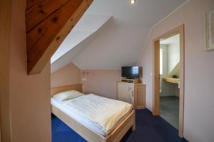 菲施巴赫莱斯科勒瓦莱夫酒店的一间小卧室,配有一张床和电视