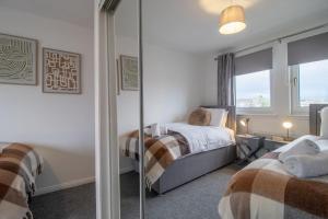 马瑟韦尔Park View-modern 2 bed apartment的一间卧室配有两张床和镜子