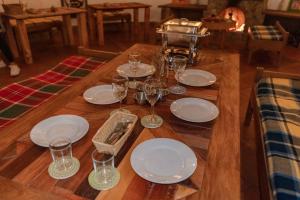 圣埃伦娜Alma Hotel Campestre的一张木桌,上面放有盘子和酒杯