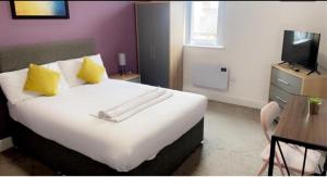 韦克菲尔德Sandal Park View - Duplex Relocations的卧室配有一张带黄色枕头的大型白色床。