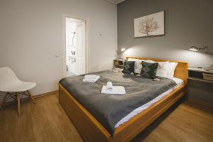 里加贝尔斯理市中心公寓的一间卧室配有一张床,上面有两条毛巾