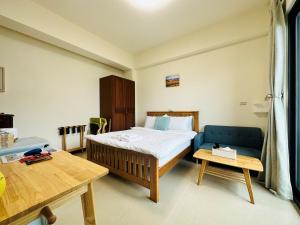 竹北新竹比斯 Hsinchu Peace的一间卧室配有一张床和一张蓝色的沙发