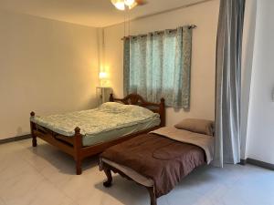 บ้านพวงชมพู By ชมภู ชุมแพ โฮมสเตย์ ไร่คุณต๋ง的一间卧室设有两张床和窗户。