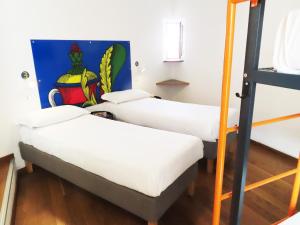 那不勒斯Tric Trac Hostel的墙上画画的房间的三张床