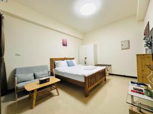 竹北新竹比斯 Hsinchu Peace的一间卧室配有一张床、一张沙发和一张桌子