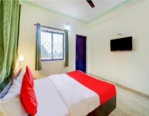 巴加Hotel Adam's Baga Beach Resort Goa - 2 minutes walk from Baga Beach的卧室配有红色和白色的床和电视。