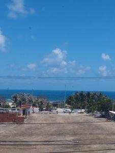 福塔莱萨Villa Del Sol Hotel Fortaleza的一个空的停车场,后面是大海