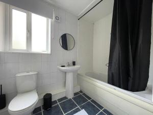 谢菲尔德Spacious 2BR Apartment w/Parking Near City Centre的浴室配有卫生间、盥洗盆和浴缸。