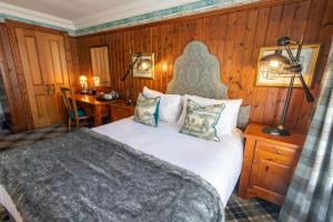 邓凯尔德邓凯尔德之家酒店的一间卧室配有一张床、一张桌子和一张桌子