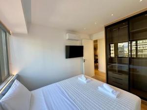 比雷埃夫斯BlueMotion - TwinBedroomPortApartment 3B的卧室配有白色的床和2条毛巾