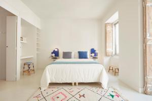 里斯本Casa Pavão的一间白色卧室,配有床和地毯