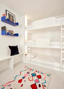 里斯本Casa Pavão的卧室配有白色双层床和地毯。