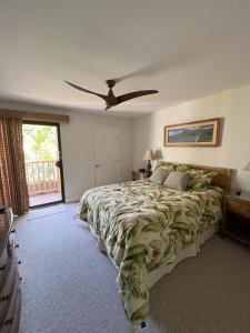 维雷亚Tropical Maui Kamaole B-Bldg的一间卧室配有一张床和吊扇