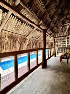 帕洛米诺Tiki Hut Hostel的享有稻草小屋的游泳池景致