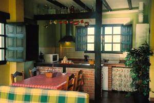SoñaCasa Rural El Pozo Tremeo的一间带桌子的厨房和一间带炉灶的厨房