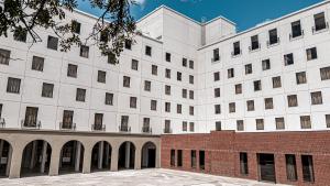 加里波第Plaza Hotel & Boulevard Convention - Vale dos Vinhedos的一座白色的大建筑,设有砖砌庭院