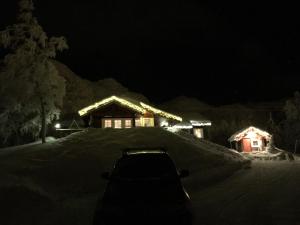 海姆瑟达尔Roni Chalet Hemsedal - Holdeskaret的停在房子前面的雪地里的汽车