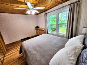特拉弗斯城Creekside Hot Tub-Walk to Beach-Uniquely Northern的一间卧室配有一张带吊扇和窗户的床。